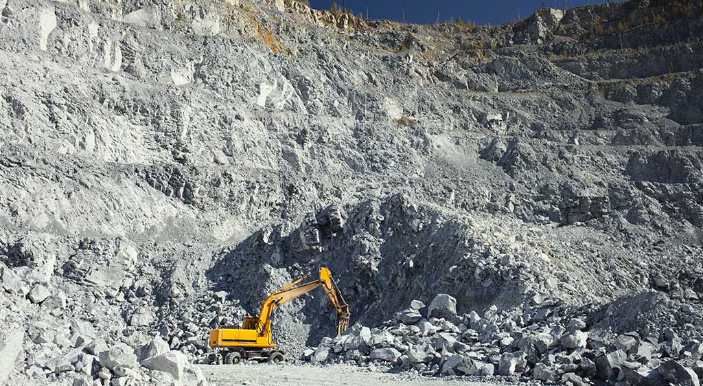 an excavator in a lime quarry
